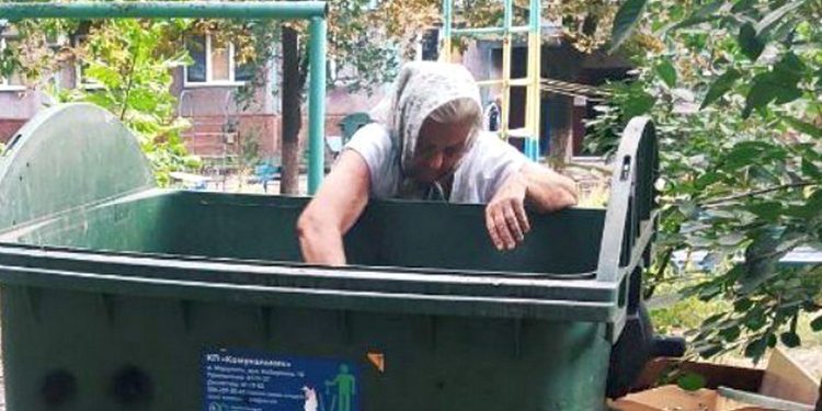 Пенсіонерка біля сміттєвого бака.